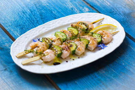 Shrimps skewers with zucchini on wooden backgroundの写真素材
