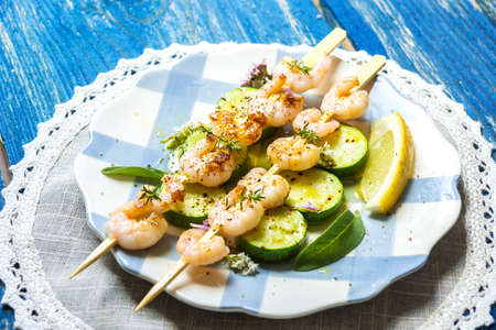 Shrimps skewers with zucchini on wooden backgroundの写真素材