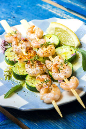 Shrimps skewers with zucchini on wooden backgroundの写真素材