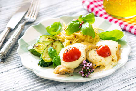 Italian lunch: chicken with mozzarella ,spaghetti and zucchiniの写真素材
