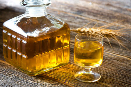 Glasse of brandy or cognac and bottle on  wooden table.の写真素材