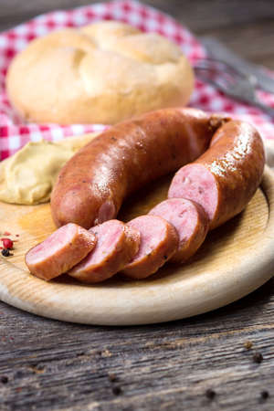 Boiled sausages on rustic round wooden boardの写真素材