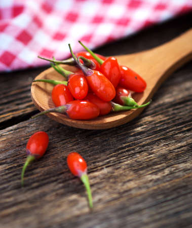 Fresh goji berries on wooden backgroundの写真素材
