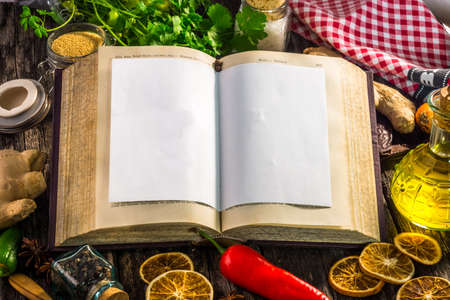 Open recipe book with  ingredients on wooden backgroundの写真素材