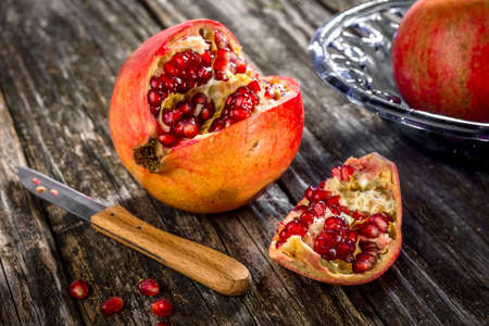 Juicy pomegranates on wooden backgroundの写真素材