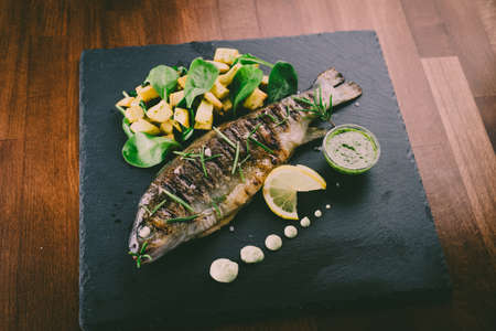 Grilled trout with potato and spinachの写真素材