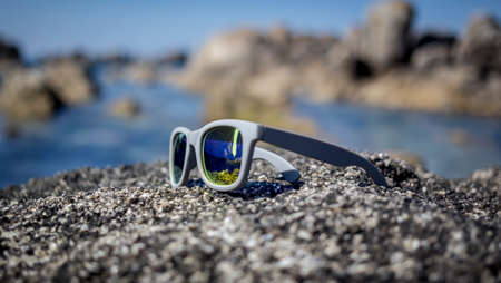 gray sunglasses sun on the rock on the beachの写真素材