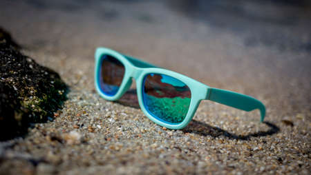 blue sunglasses sun on the beach sandの写真素材