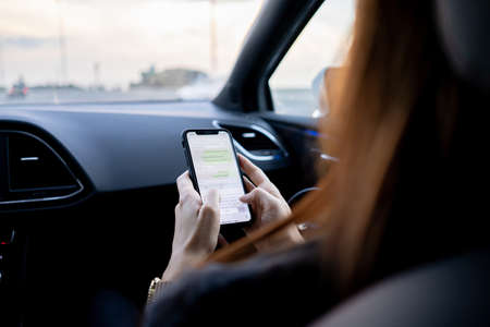 Woman using phone while traveling in car
