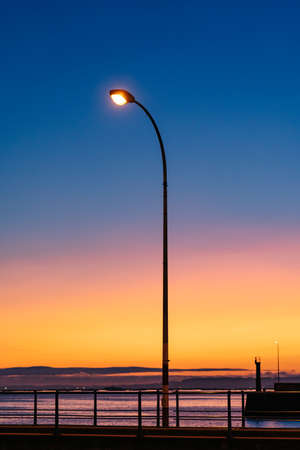 Lampposts lit at sunset