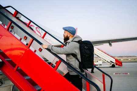A man gets on the plane from the runway down the stairsの写真素材