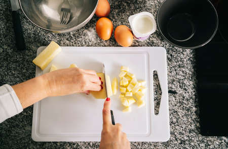 A woman prepares the ingredients to make a sponge cake in her home kitchenの写真素材