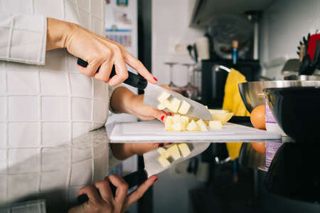 A woman prepares the ingredients to make a sponge cake in her home kitchenの写真素材