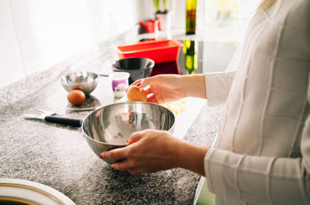 A woman prepares the ingredients to make a sponge cake in her home kitchen