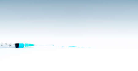 Isolated syringe with blue liquid on white background. Medicine and health concept in the face of a pandemic or virus.の写真素材