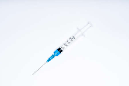 Isolated syringe with blue liquid on white background. Medicine and health concept in the face of a pandemic or virus.の写真素材