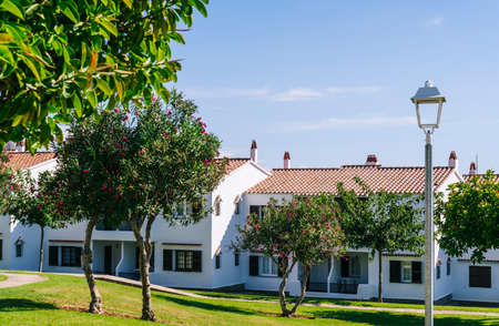 Tourist apartments with white facade with green grass and blue sky on a sunny dayの写真素材