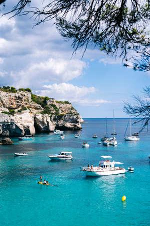 MENORCA, SPAIN. 3 SEPTEMBER 2020. Panoramic view of Cala Macarelleta with people on their boats...