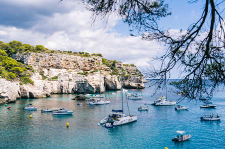 MENORCA, SPAIN. 3 SEPTEMBER 2020. Panoramic view of Cala Macarelleta with people on their boats...