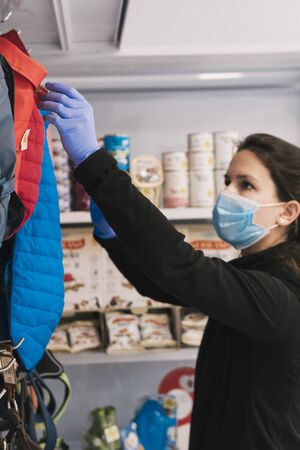 Beautiul caucasian female veterinary with blue protection mask ordering clothes in the pet shopの写真素材