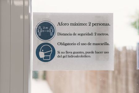 Poster with prevention regulations indicating measures against covid 19 in a small business in a...