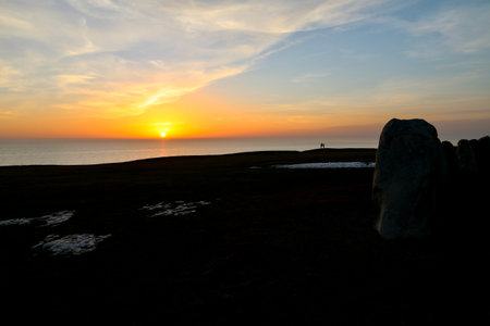 Colorful partially cloudy sky at sunset over the sea. Silhouettes of Ales Stenar megalithic monument in Kaseberga, Scania, Sweden, February 2021.の写真素材