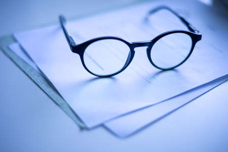 Glasses on paper slight reflection black whiteの写真素材
