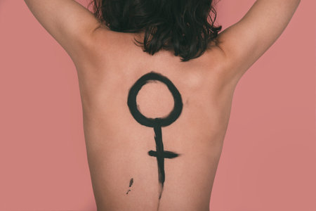 Caucasian woman with the female symbol painted on her backの写真素材