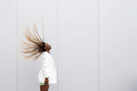 Young african american woman tossing long blond braided hair back. Copy space.の写真素材