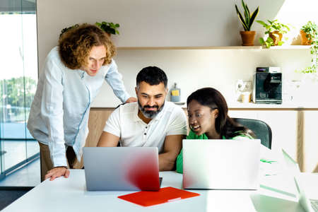 Multiracial group of colleagues look at laptop together. Copy space. Business concept. Technology concept.の写真素材