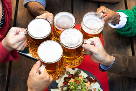 Top view of multiracial friends toasting with tasty beer.の写真素材