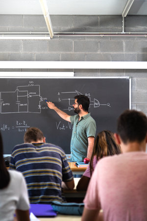 High school male teacher teaching lesson to multiracial teen students. Vertical image.