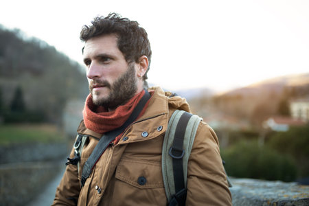Portrait of caucasian man outdoors in nature during fall season. Male hiker going on excursion.の写真素材