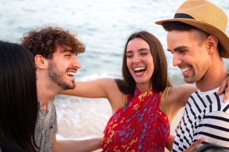 Group of friends laugh together embracing at the beach. Friendship and summer vacationsの写真素材