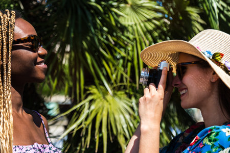Young woman taking picture of female friend during summer vacation.