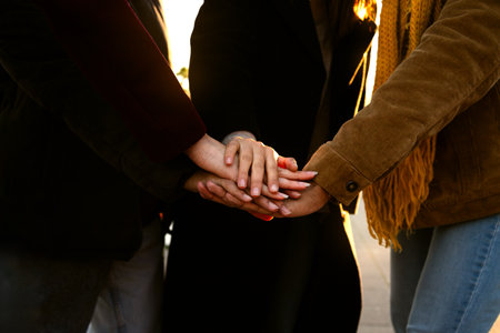 Close up shot of unrecognisable young people stacking hands as a symbol of unity, community and...