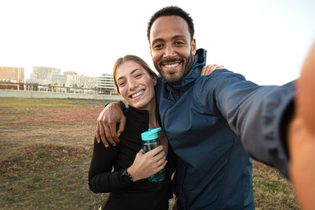 Multiracial couple taking selfie after workout outdoors. Sporty couple taking self portrait after...