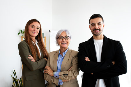 Portrait of three happy coworkers smiling looking at camera standing in the office.の写真素材