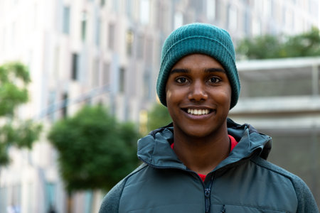Happy young African American man looking at camera. Black male in winter clothing outdoors smiling. Copy space.の写真素材