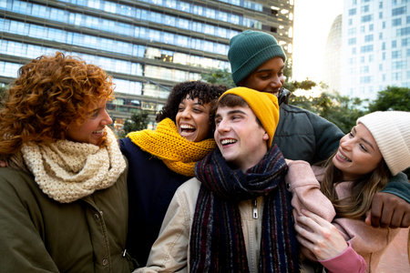 Happy multiracial friends laughing and having fun together during winter time outdoors in the city.の写真素材