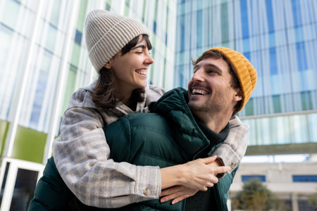 Happy tourist couple piggybacking and having fun in urban city
