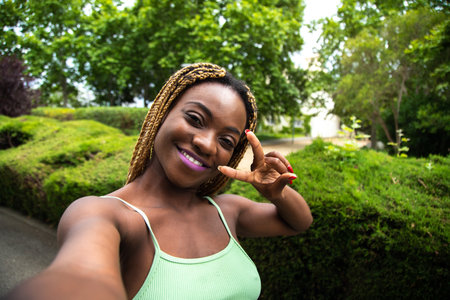 Happy woman, runner taking selfie while running outdoors in the park looking at camera. Copy space.の写真素材