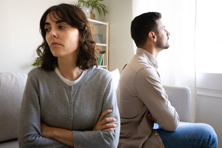 Couple ignoring each other sitting on the couch. Couple fighting at home. Relationship difficulties.の写真素材