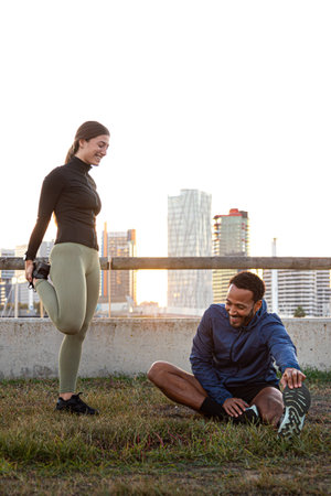 Athletes stretching together in a city park at sunset: embracing fitness and urban lifestyle