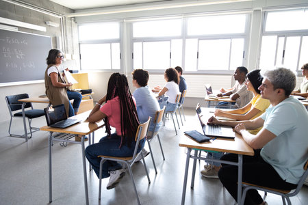 Teacher explaining lesson to diverse group of high school studentsの写真素材