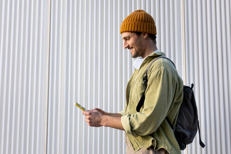 Smiling tourist using smartphone while walking in the cityの写真素材
