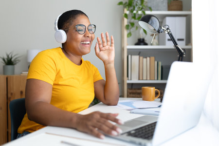 Smiling female freelancer greeting during video call from home officeの写真素材