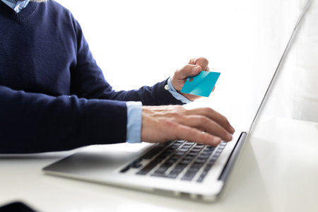 Senior businessman making online payment using laptop and credit cardの写真素材