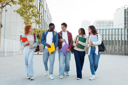 Happy university students walking and talking on campusの写真素材