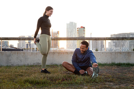 Athletes stretching together at sunset in the city: promoting health and fitnessの写真素材